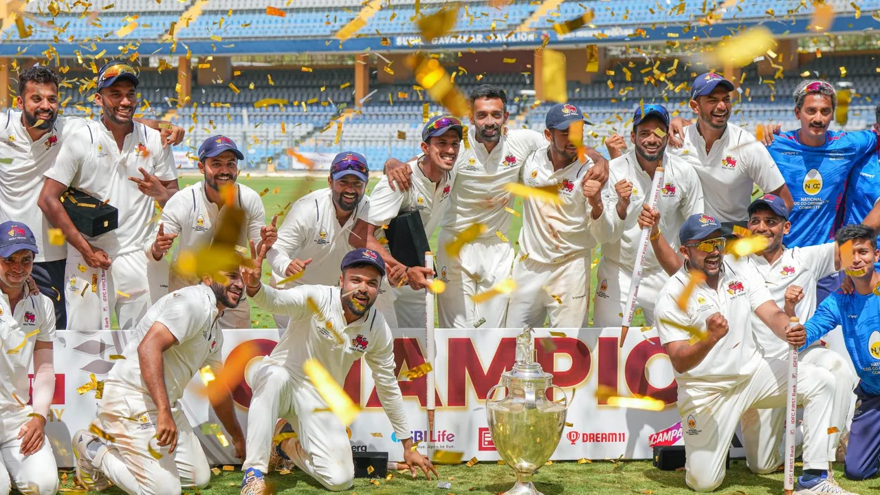 Mumbai players celebrate with the championship trophy after winning the Ranji Trophy final