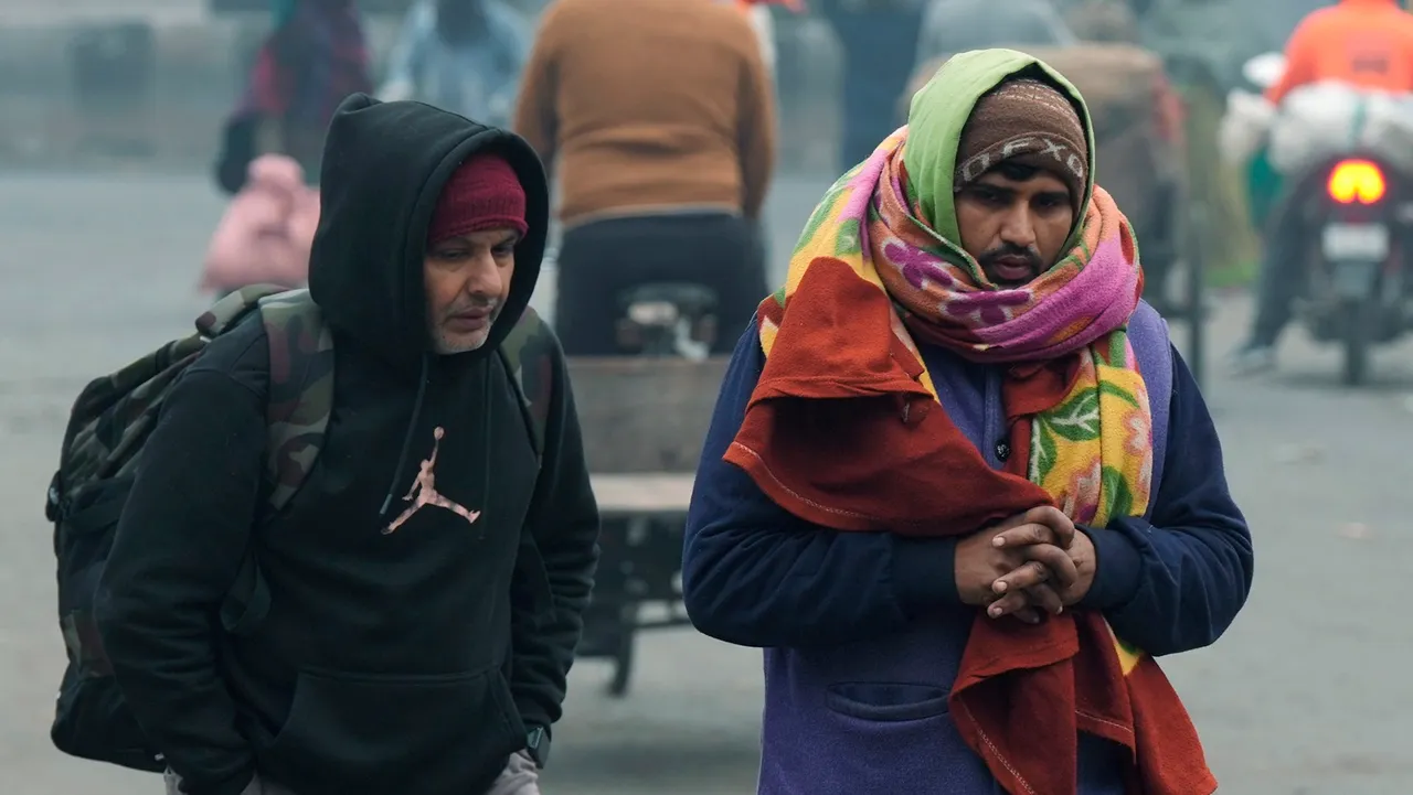 Commuters wearing warm clothes during a cold and foggy winter morning, in New Delhi
