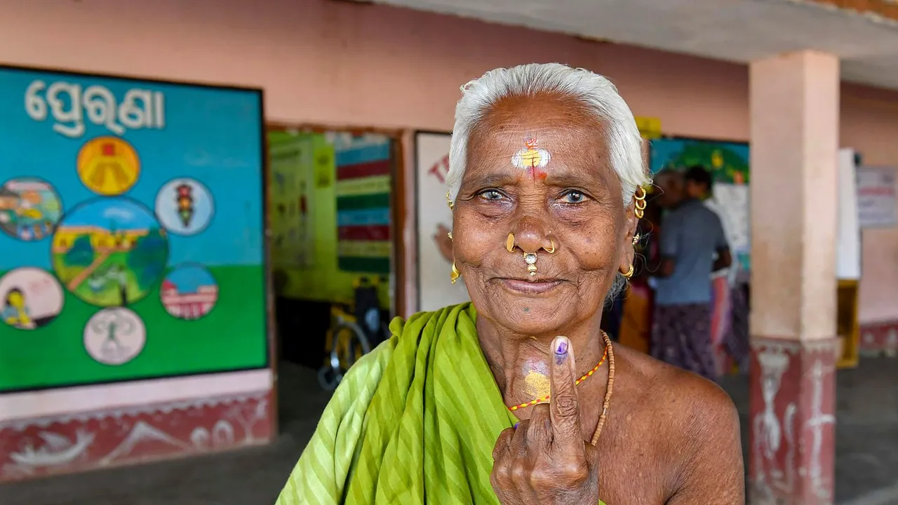 An elderly woman shows her inked finger after casting her votes at a polling booth during the fourth phase of General Elections-2024 at Gopalpur in Berhampur, Odisha, Monday, May 13, 2024
