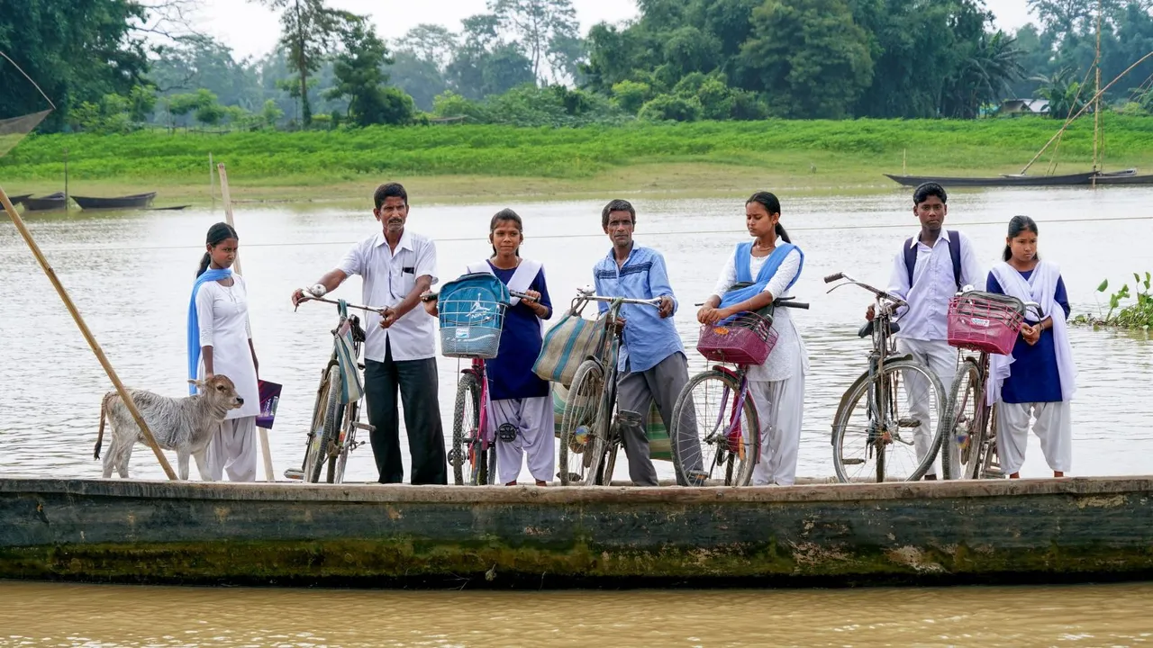 School students and others take a boat ride across the Brahmaputra River, in Morigaon district