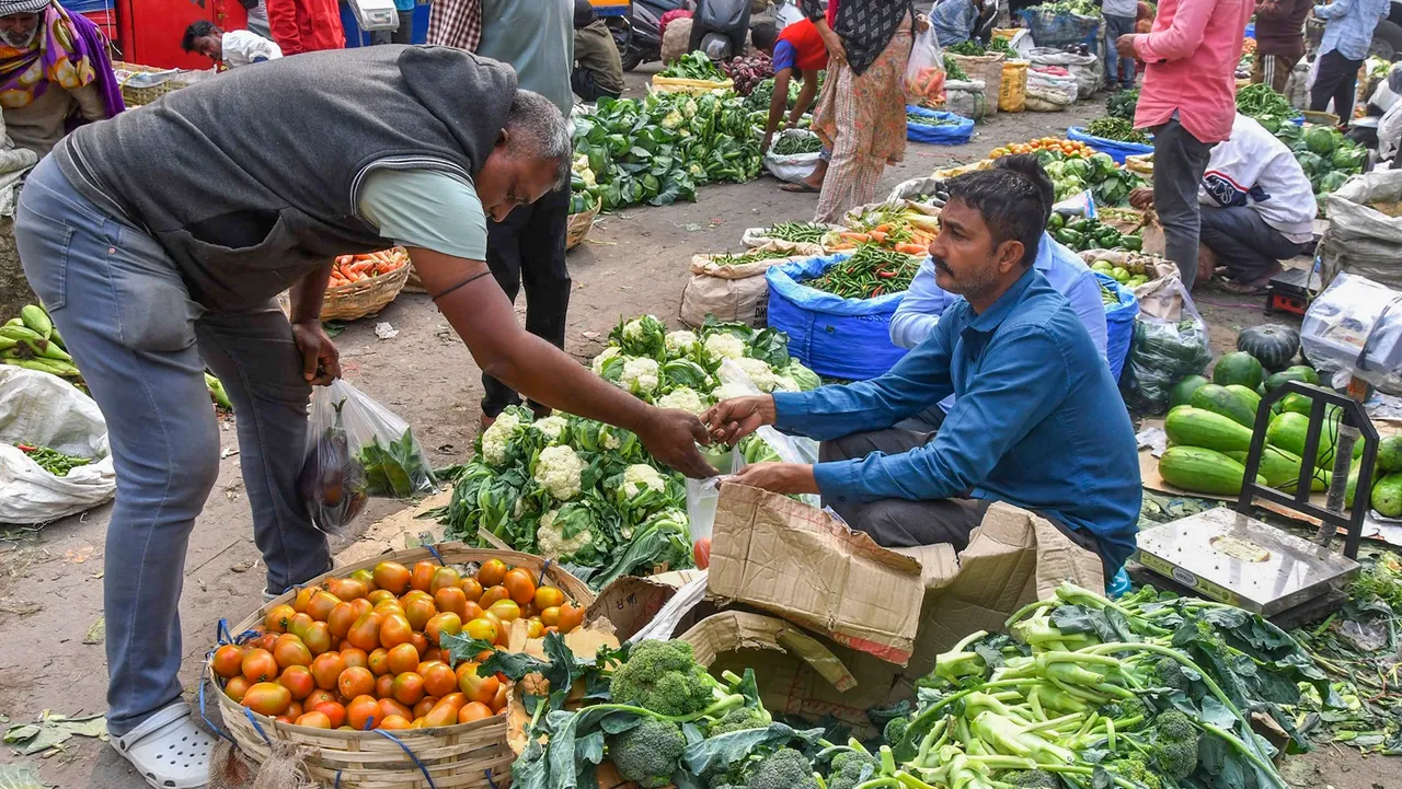 A customer buys vegetables at a market in Guwahati