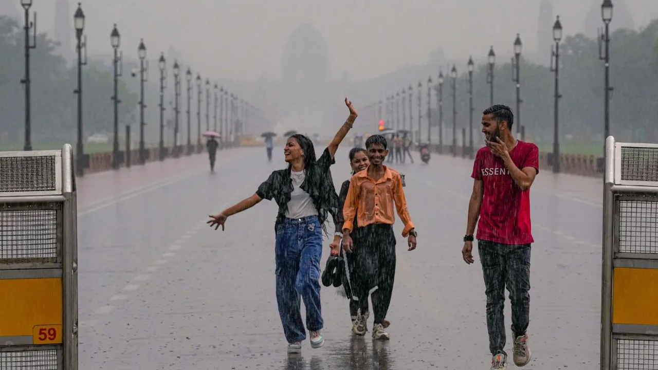 People enjoy during rains, at Kartavya Path in New Delhi, Friday, Sept. 13, 2024