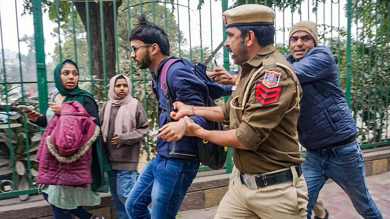 Delhi Police personnel detain a student after Students' Federation of India (SFI)'s announcement to screen the BBC documentary on Prime Minister Narendra Modi at the Jamia Millia Islamia campus