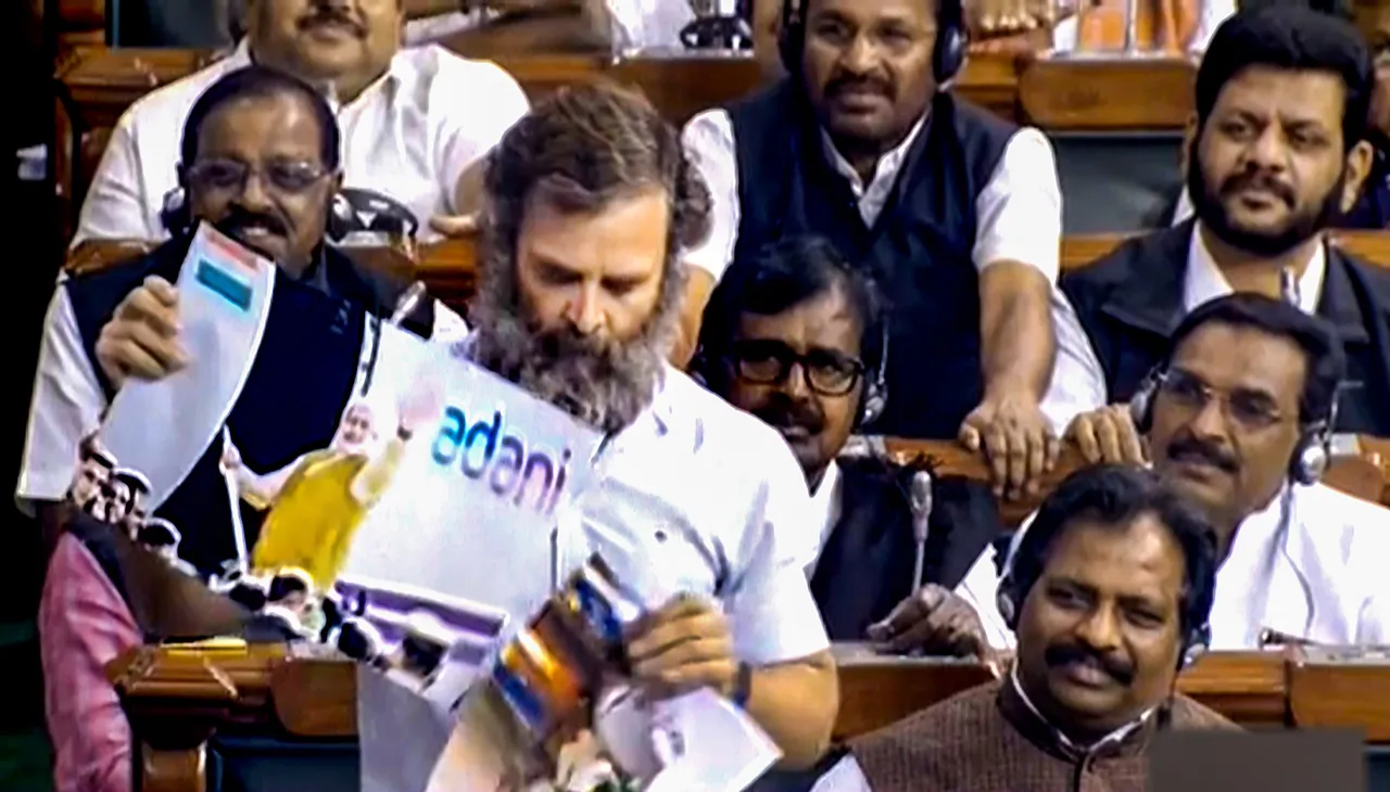 Rahul Gandhi showing posters related to Narendra Modi and Gautam Adani