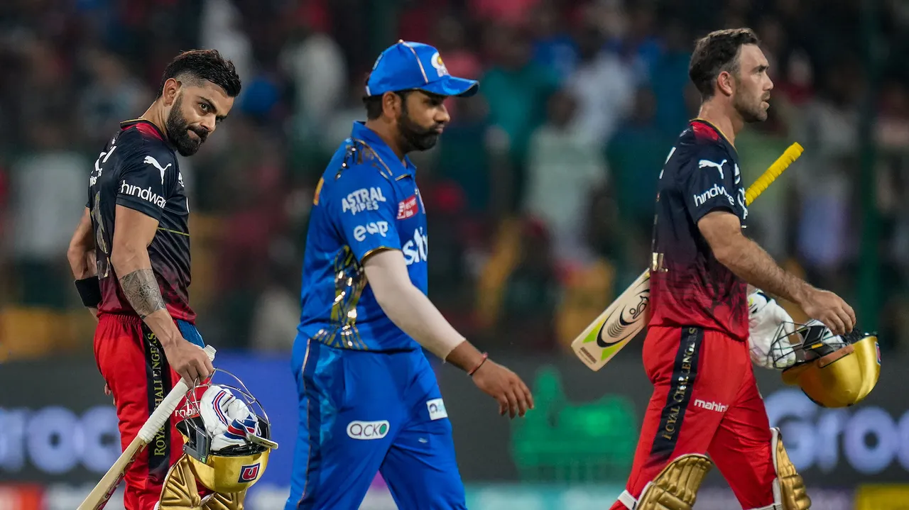 Royal Challengers Bangalore batters Virat Kohli and Glenn Maxwell walk back after winning over Mumbai Indians as Mumbai Indian captain Rohit Sharma also walks in dejected look during the IPL 2023 match between Royal Challengers Bangalore and Mumbai Indians at M Chinnaswamy Stadium in Bengaluru on April 2