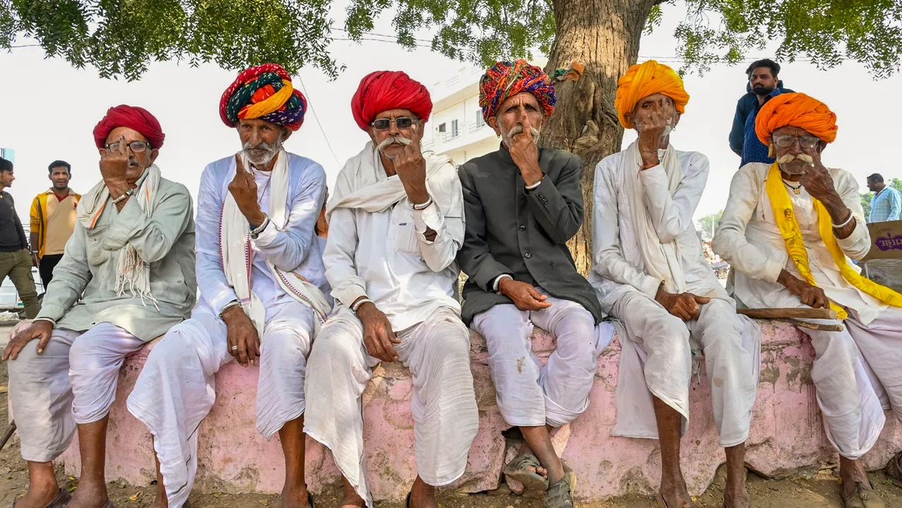 Villagers show their ink-marked fingers after casting votes for the Rajasthan Assembly elections, in Ajmer