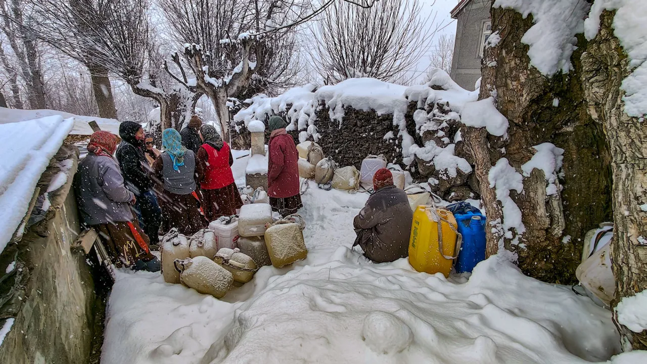 Residents collect drinking water from a tap during snowfall at Rashel village, inLahaul and Spiti district, Sunday, Feb. 4, 2024.