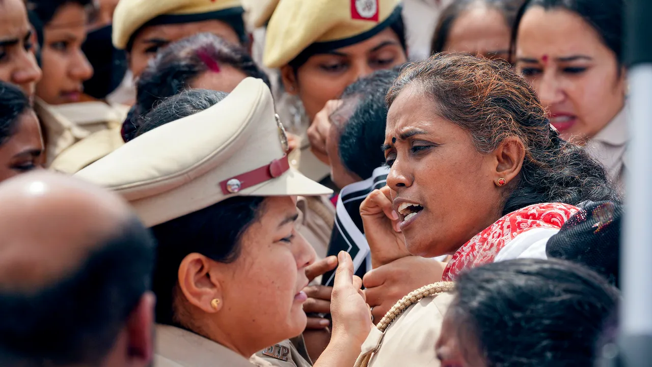 Congress MP Jothimani Sennimalai in a scuffle with police personnel during a protest march towards Rashtrapati Bhawan, at Vijay chowk in New Delhi, Friday, March 24, 2023. Opposition parties are protesting against the conviction of Rahul Gandhi in a criminal defamation case and demanding JPC probe into the Adani-Hindenburg issue