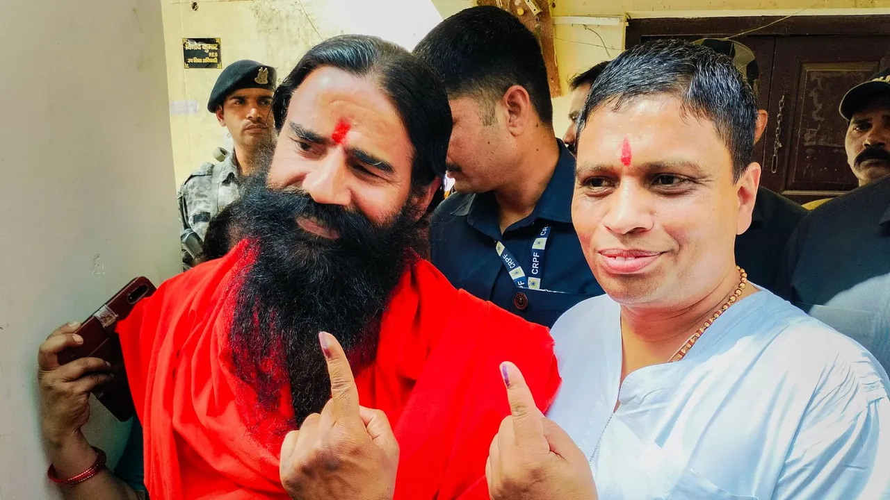 Yoga guru Ramdev and Patanjali MD Acharya Balkrishna show their fingers marked with indelible ink after casting their votes for the first phase of Lok Sabha elections, in Haridwar, Friday, April 19, 2024