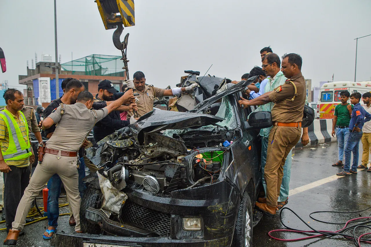 olice personnel and others near the wreckage of a car after a head-on collision with a bus on Ghaziabad-Meerut Expressway, in Ghaziabad