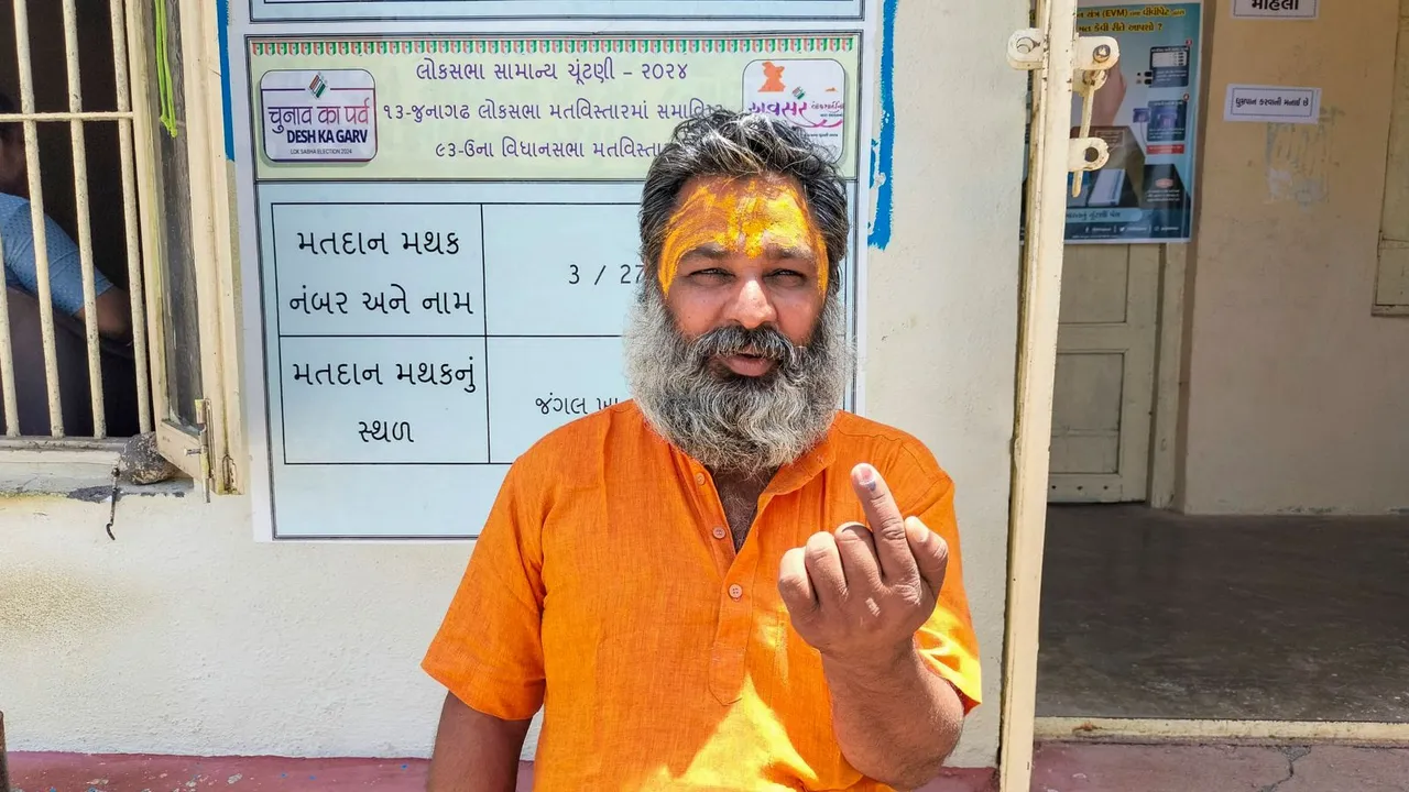 A man shows his inked finger after casting his vote at a polling station set up in the Gir forest, Banej, Tuesday, May 7, 2024