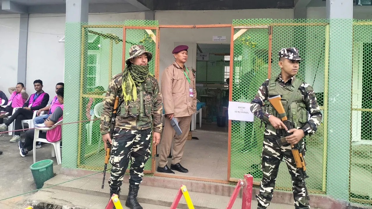 Security personnel stand guard outside a counting centre during counting of votes for the Mizoram Assembly elections, in Serchhip district of Mizoram