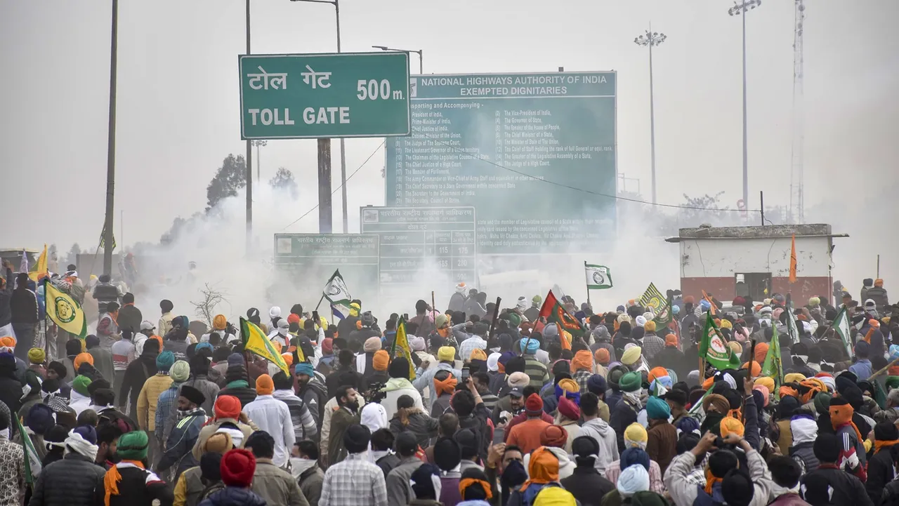 Farmers move away after police fired teargas shell to disperse them during their 'Delhi Chalo' march at Punjab-Haryana Shambhu border