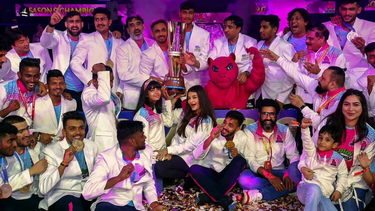 Bollywood actors Abhishek and Aishwarya Rai Bachchan with their daughter Aaradhya Bachchan pose for photos with the players of the former's team 'Jaipur Pink Panthers' after they won the final match of Pro Kabaddi League 2022, in Mumbai, Saturday night