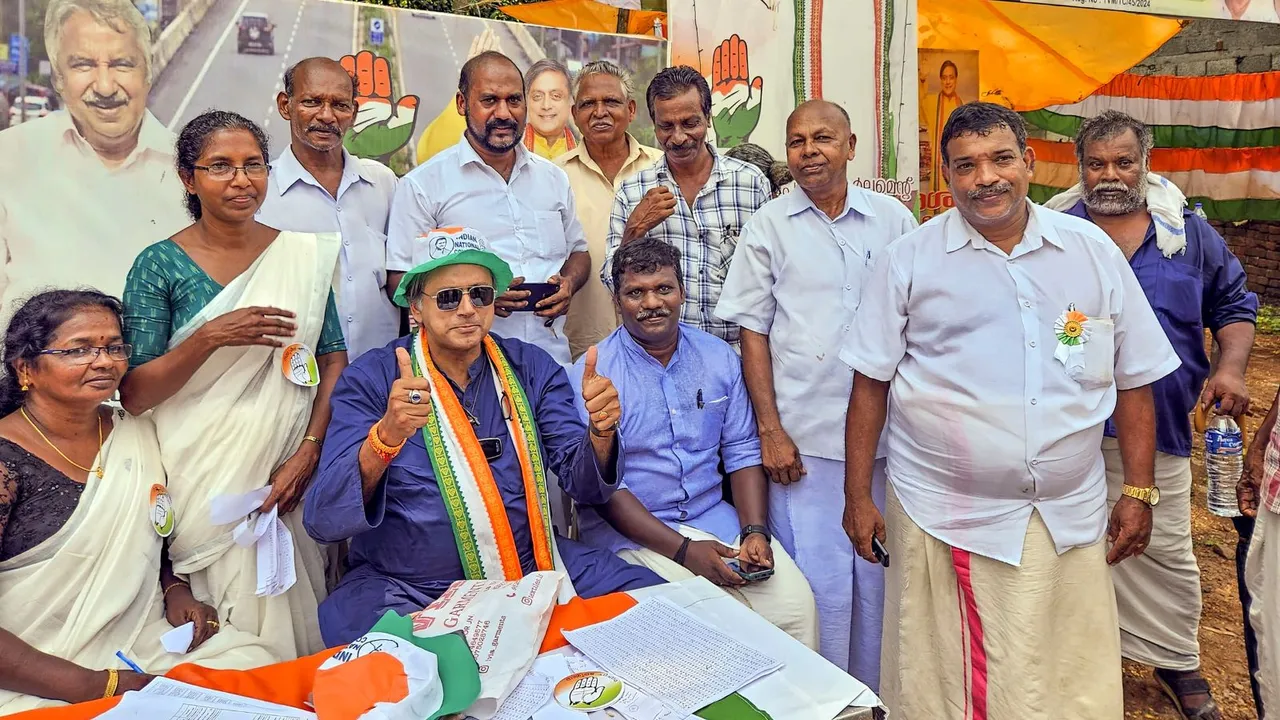 Congress candidate Shashi Tharoor poses for photos with party workers at a polling station during voting for the second phase of Lok Sabha elections, in Thiruvananthapuram, Friday, April 26, 2024