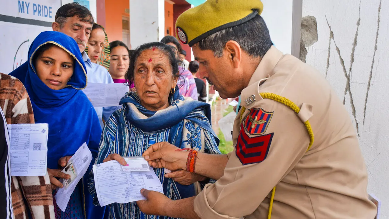 Voters wait in queues at a polling station to cast their votes for the first phase of Lok Sabha elections, in Udhampur district, Friday, April 19, 2024.