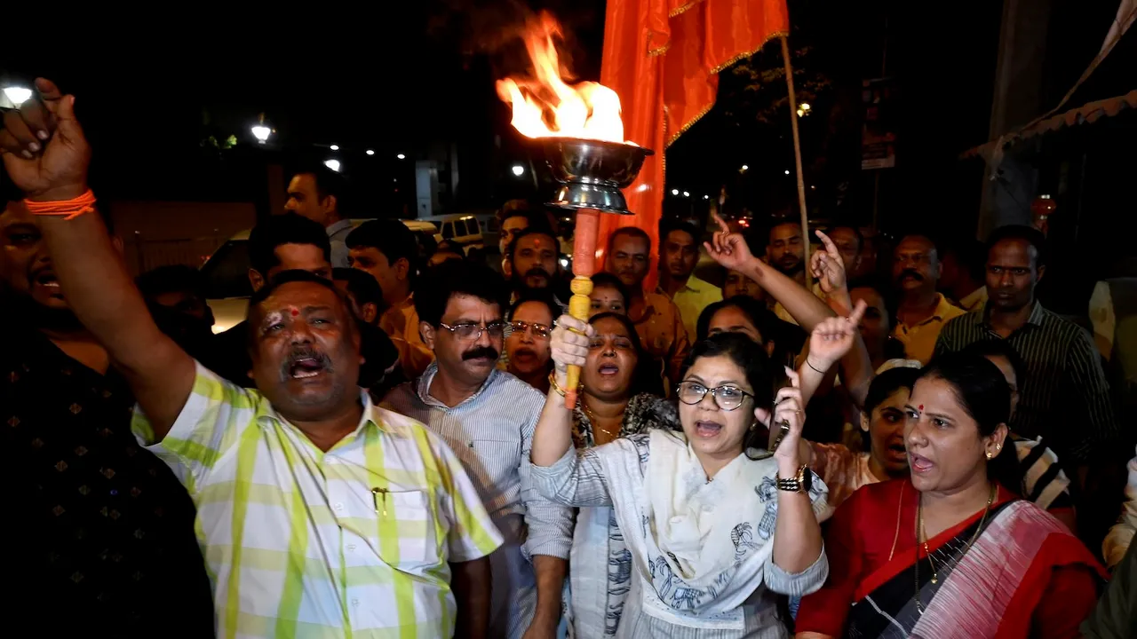 Uddhav Balasaheb Thackeray party workers and supporters carrying torch raise slogans as they gather outside 'Matoshree' in Mumbai Friday
