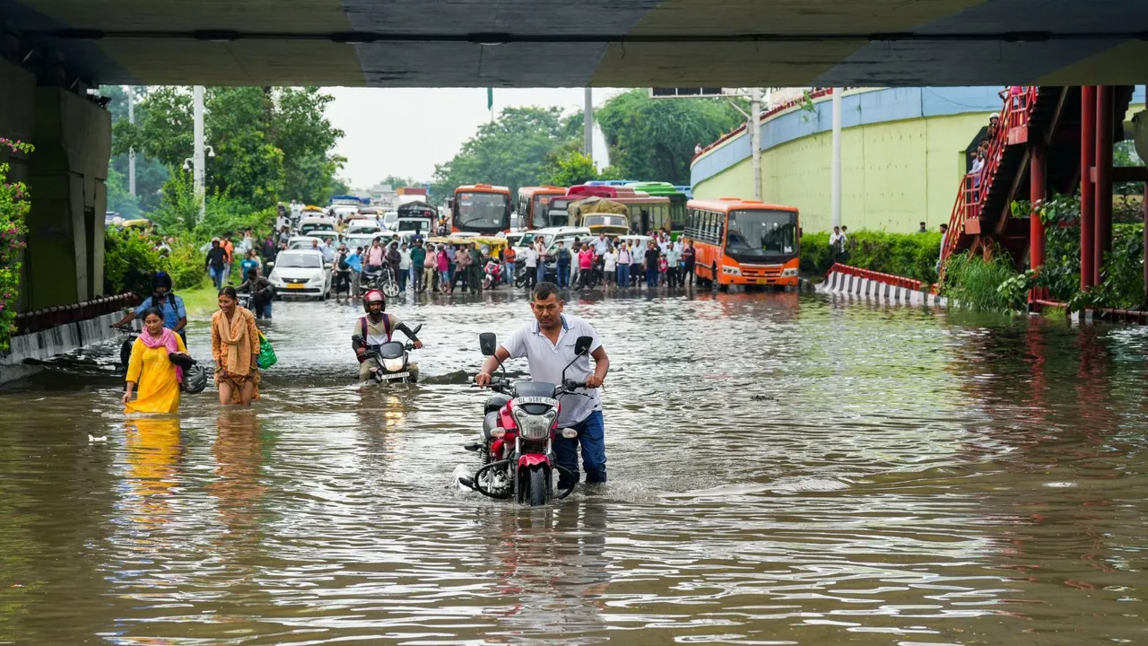 People commute through a flooded road after heavy downpour, in New Delhi, Friday, Aug. 23, 2024.