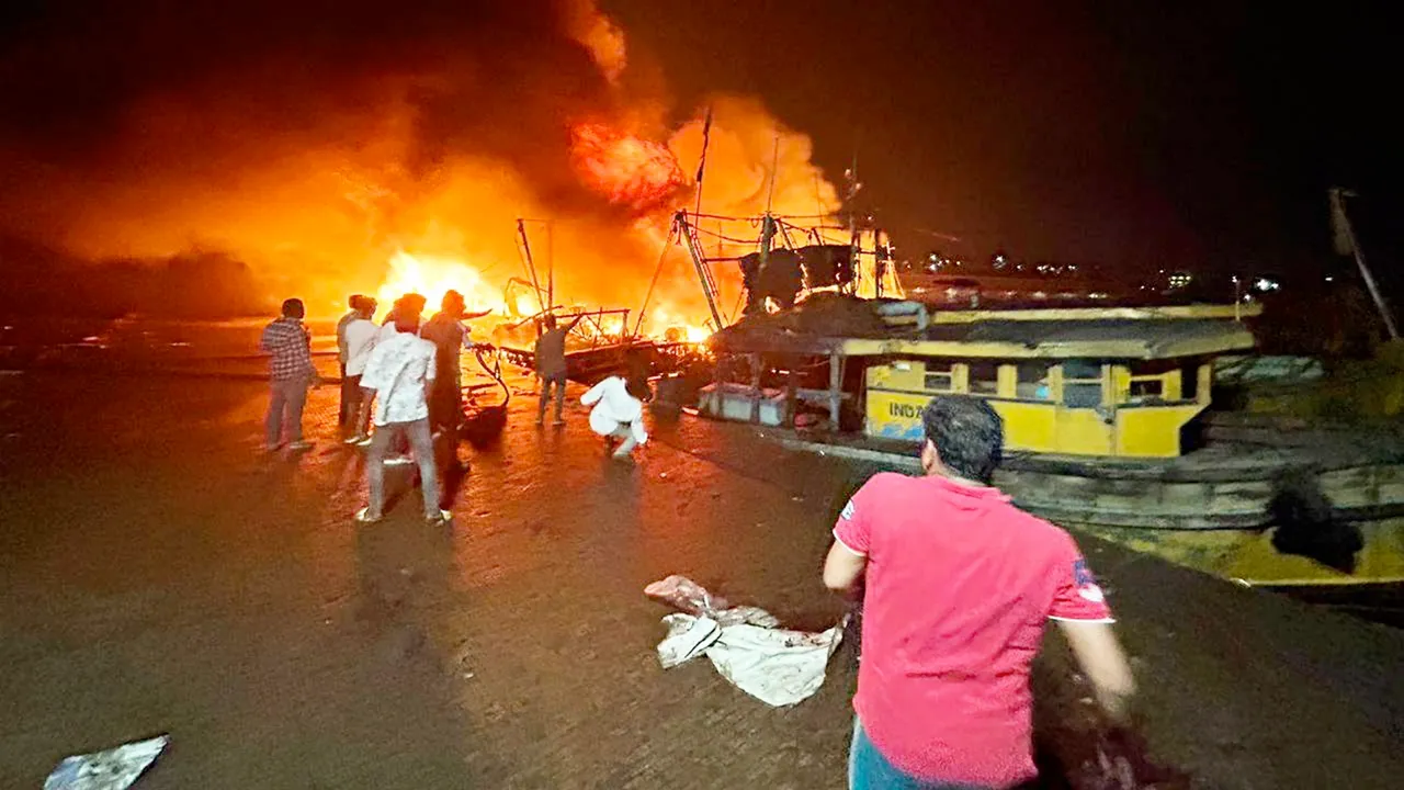 Locals at the site after a fire broke out in a jetty area, in Visakhapatnam