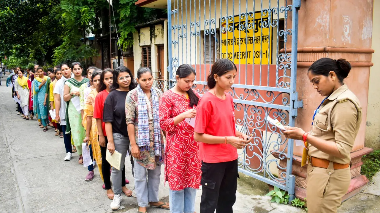 A woman police personnel checks candidates as they arrive at a centre to appear in Police Constables Recruitment Examinations, in Meerut, Friday, Aug. 23, 2024.