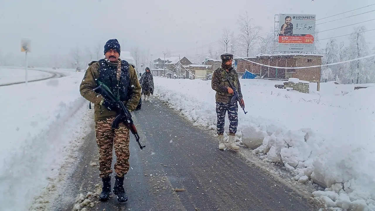 Security forces personnel patrol the Jammu-Srinagar National Highway amid snowfall, in Anantnag