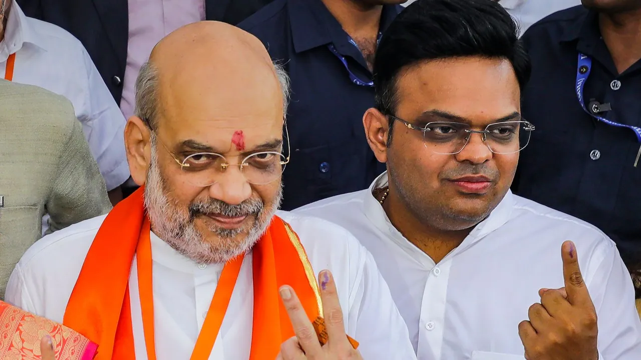 Union Home Minister Amit Shah with son Jay Shah shows his ink-marked finger after casting vote for Lok Sabha elections, in Ahmedabad, Tuesday, May 7, 2024