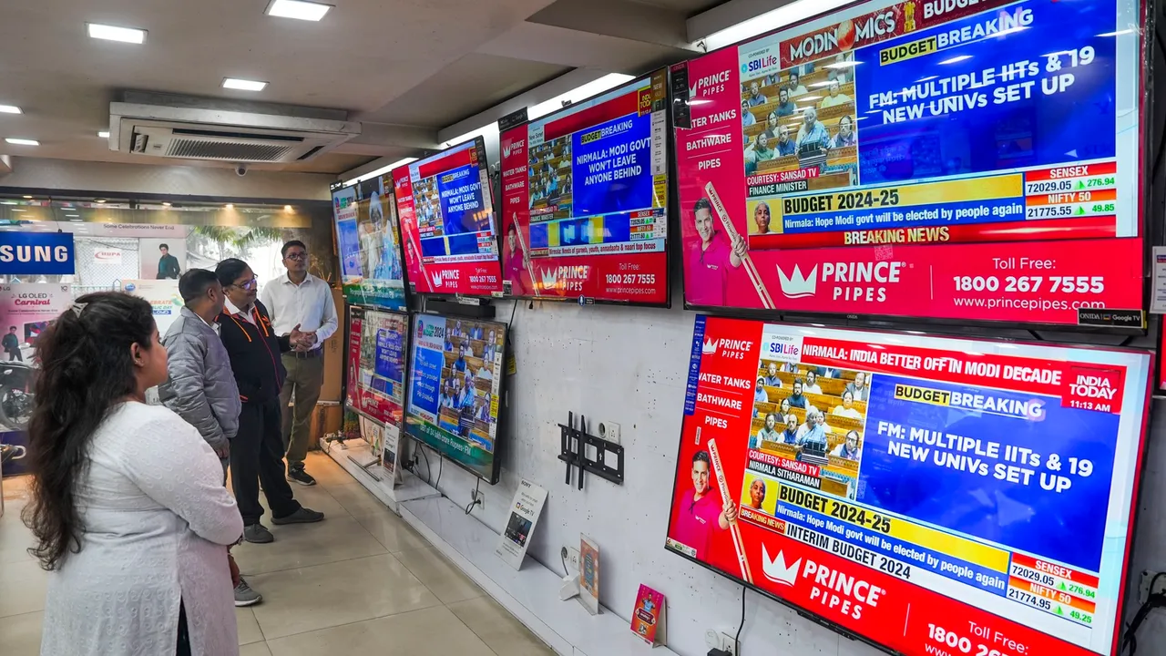 People watch Union Finance Minister Nirmala Sitharaman presenting the Interim Budget 2024 in Parliament, at a television showroom in Kolkata