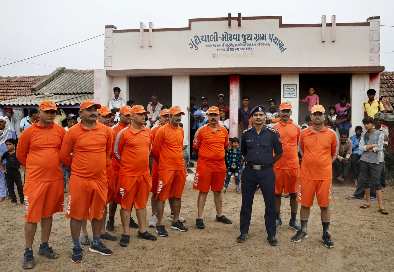 National disaster response force (NDRF) personnel brief citizens ahead of cyclone Biparjoy’s landfall, at Mandvi, in Kutch