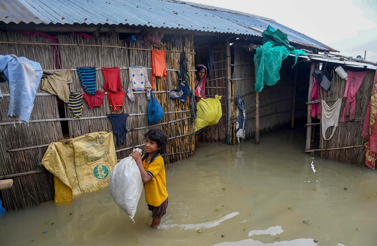 A woman and a child at their house in a flooded locality in Morigaon district of Assam