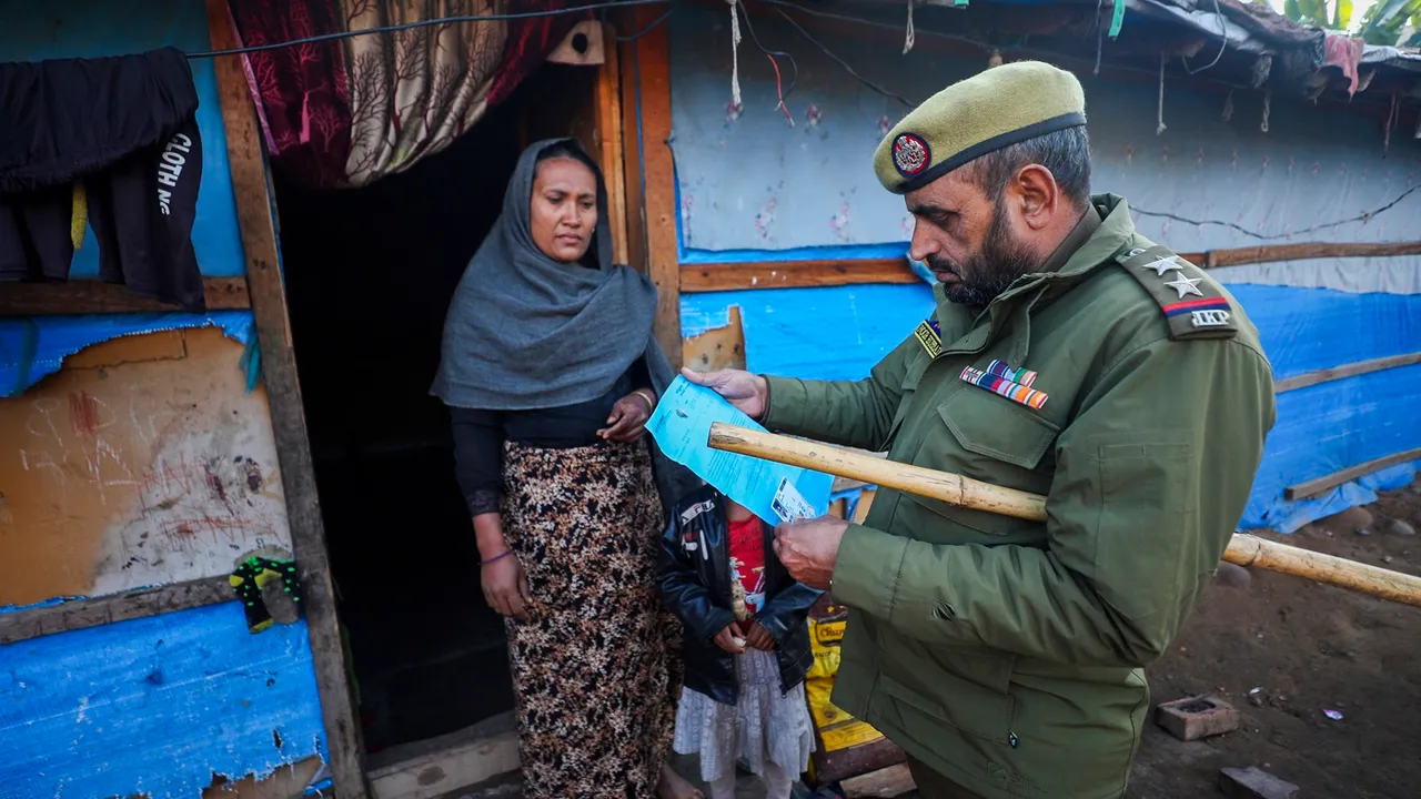 Police personnel check documents of Rohingya refugees during a search at a camp, in Jammu