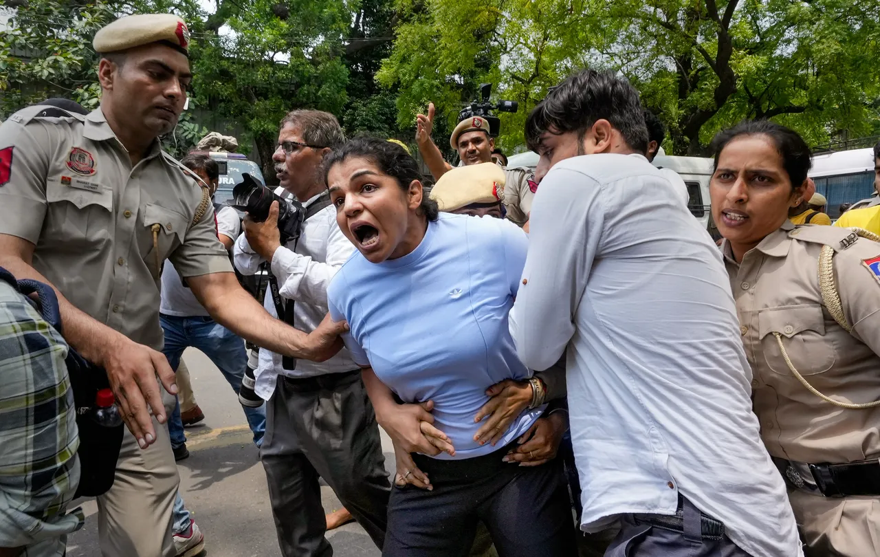 Security personnel detain wrestler Sakshi Malik during wrestlers' protest march towards new Parliament building, in New Delhi