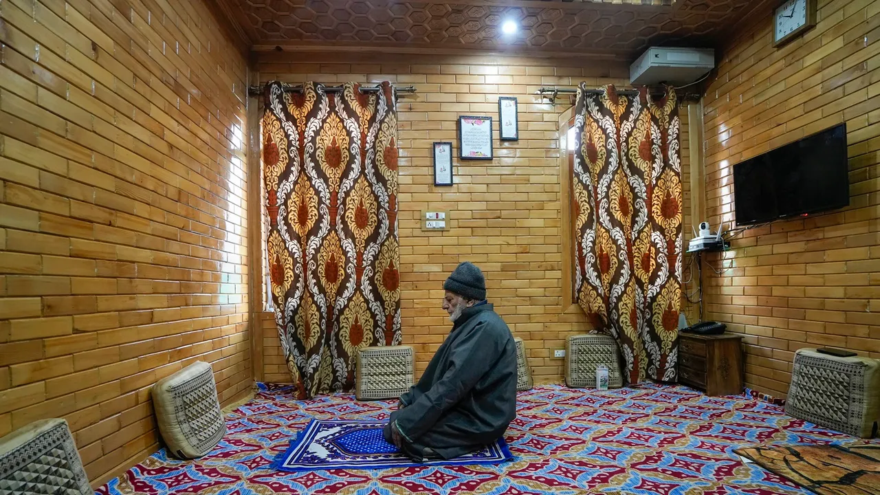 A man prays inside a 'Hamam' in his house, in Srinagar