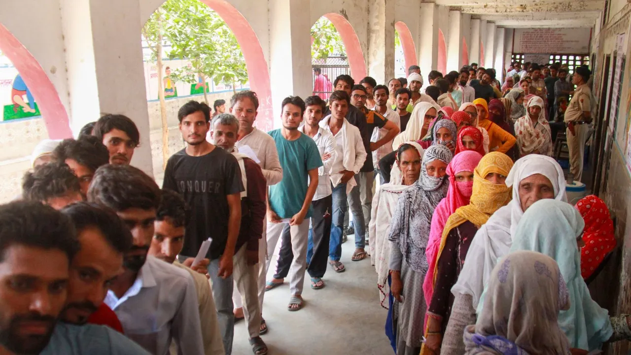 Voters stand in a queue to cast their vote at a polling station at Sohna, during the sixth phase of Lok Sabha elections, in Gurugram district, Saturday, May 25, 2024