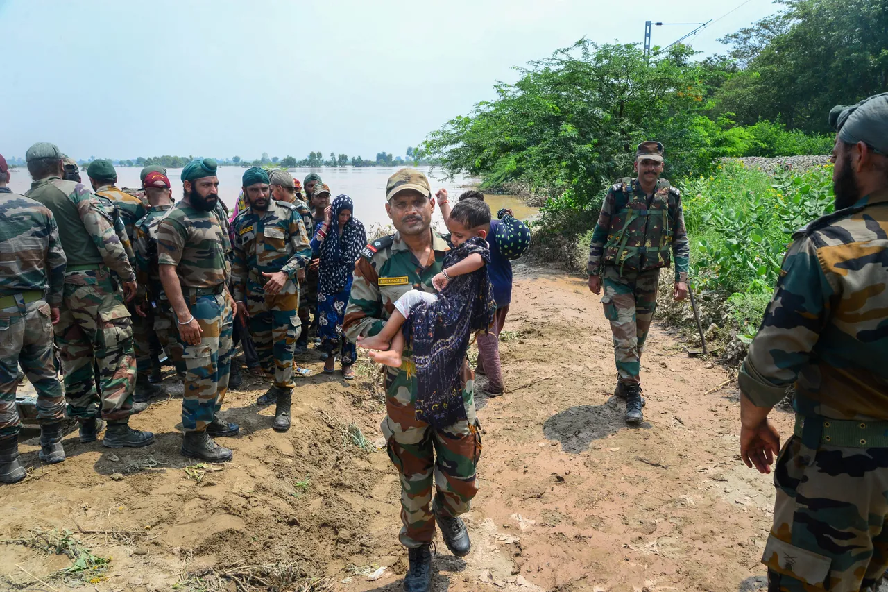 Army personnel rescue residents from a flood-affected area following monsoon rains, in Lohian area of Jalandhar district