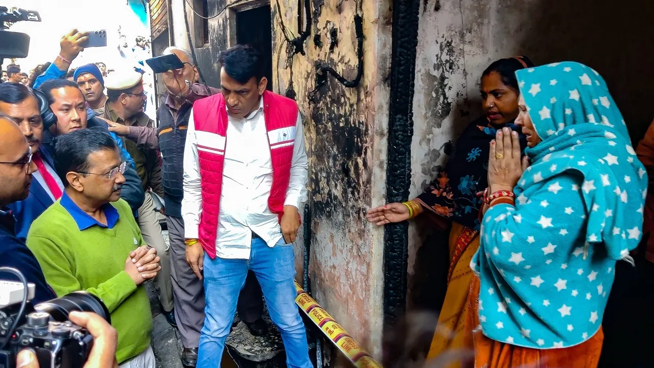 Delhi Chief Minister Arvind Kejriwal interacts with affected residents as he visits the Alipur factory fire site