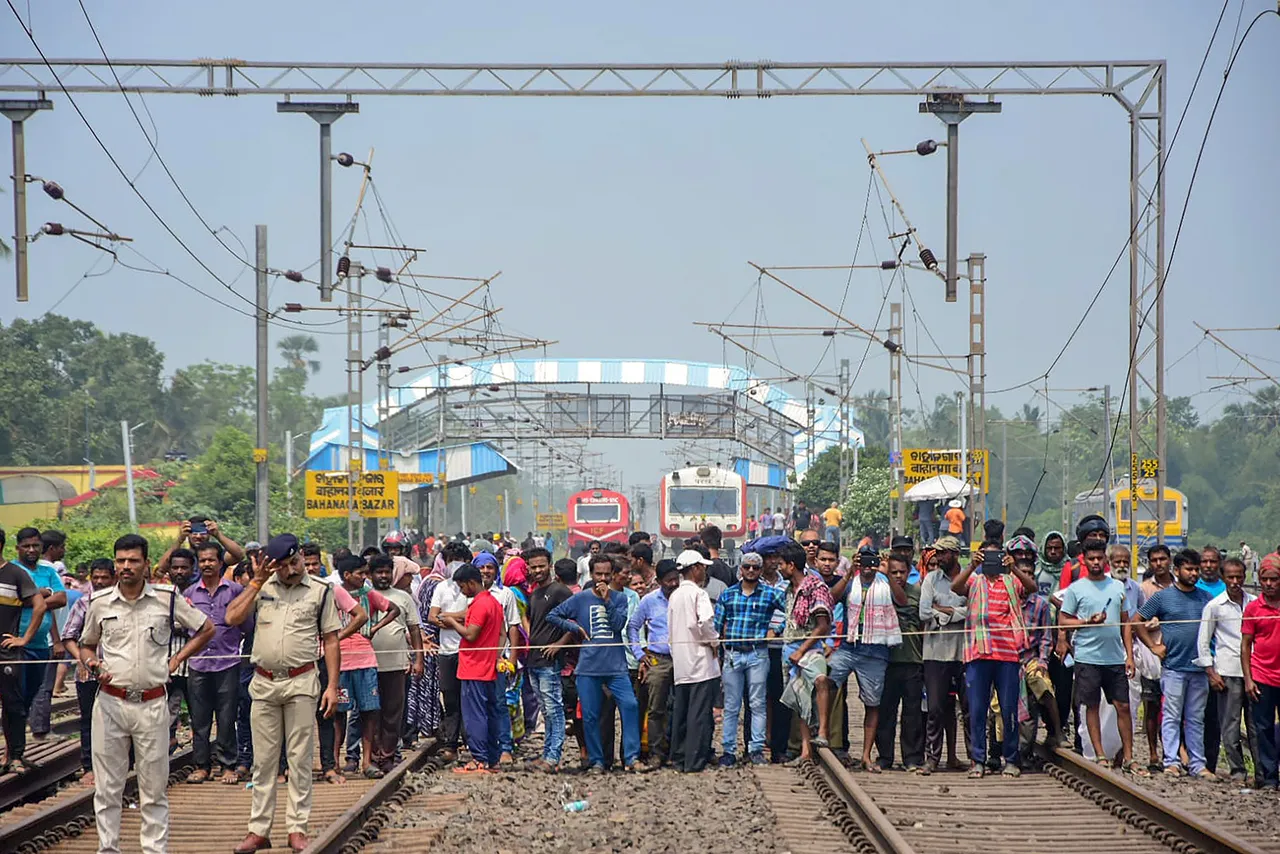 Police and locals stand as rescue work is underway after an accident involving Coromandel Express, Bengaluru-Howrah Express and a goods train