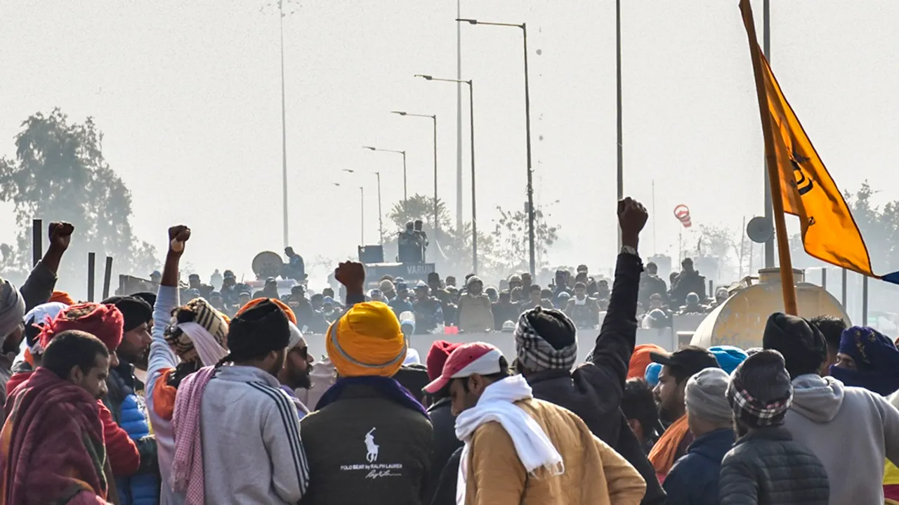 Farmers raise slogans in front of security personnel guarding at the Punjab-Haryana Shambhu border during their 'Delhi Chalo' protest, near Patiala district, Friday, Feb. 16, 2024.