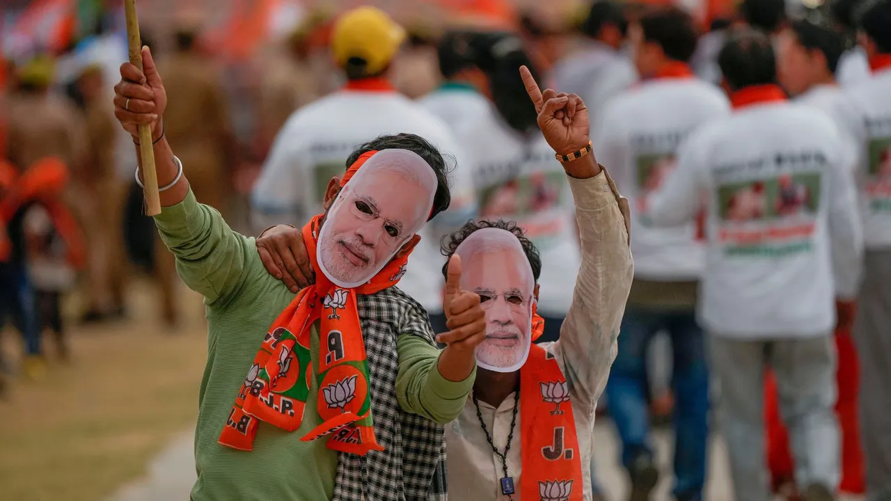 BJP supporters wear masks of Prime Minister Narendra Modi