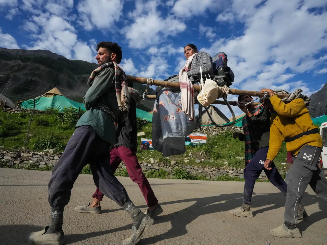 Porters carry an Amarnath yatri on a palanquin to the shrine temple from the base camp, in Baltal