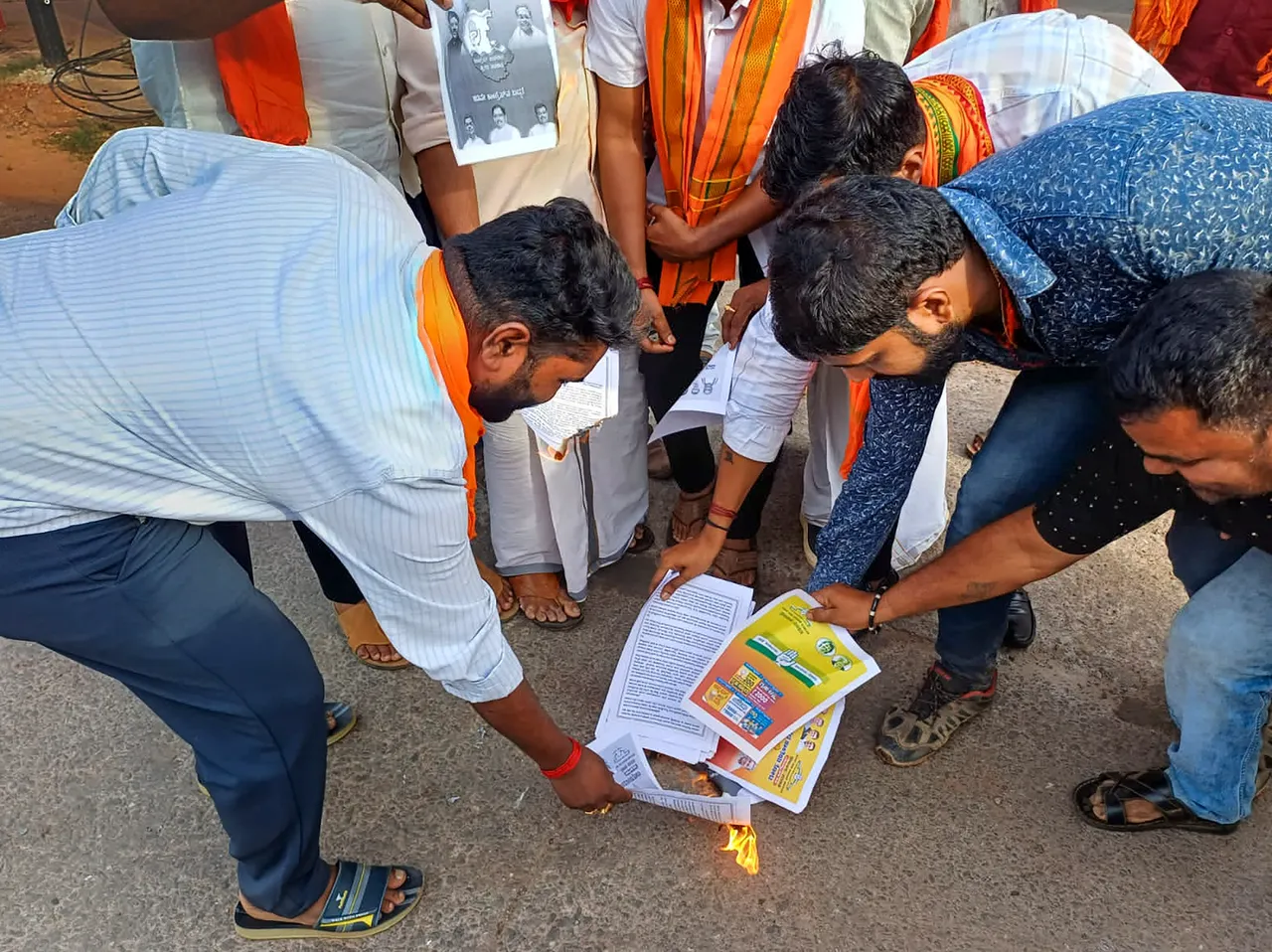 Bajrang Dal workers burn copies of Karnataka Congress manifesto during a protest in Udupi