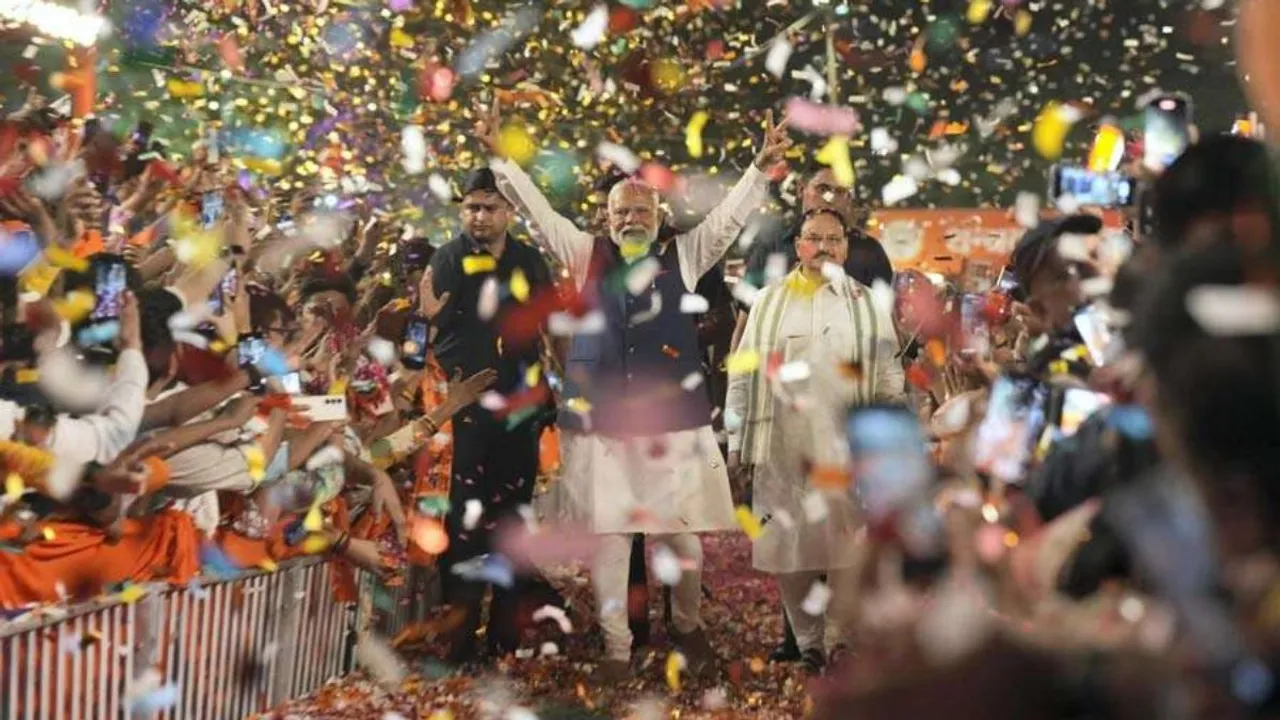 Prime Minister Narendra Modi greets party workers upon his arrival for a meeting at the party headquarters as the party leads in the Lok Sabha elections amid the counting of votes, in New Delhi