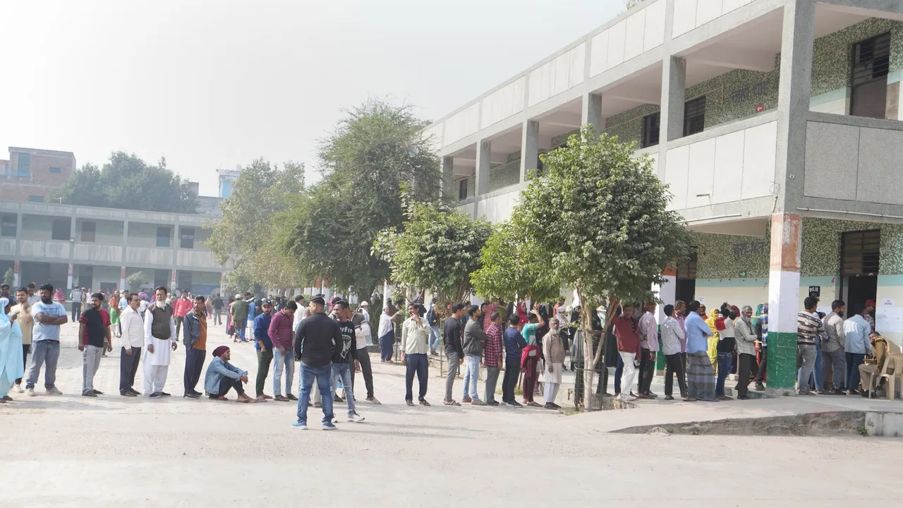 Voters wait in queues to cast their votes for the Municipal Corporation of Delhi (MCD) elections, at a polling station in Jahangir Puri area