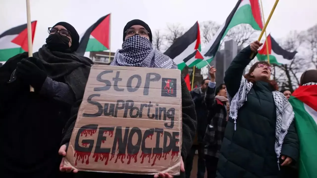 A person holds a placard as pro-Palestinian protesters gather near the International Court of Justice (ICJ) , in The Hague, Netherlands January 12, 2024 