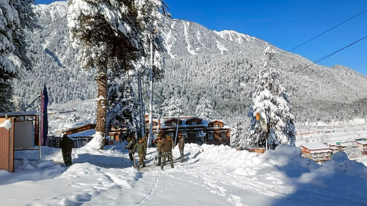 Security personnel stand guard at a snow-covered area after a fresh snowfall, in Pahalgam, Friday, Feb. 2, 2024