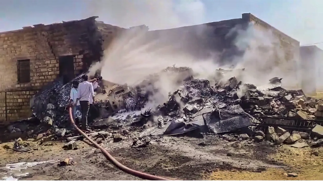 Firefighters try to extinguish the fire at the crash site after a Tejas aircraft of the Indian Air Force (IAF) crashed during an operational training sortie, near Jaisalmer