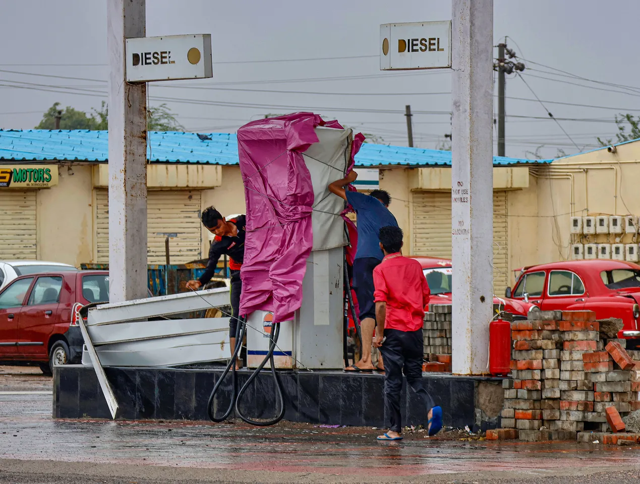 Workers cover fuel station after government’s advisory for evacuation ahead of cyclone Biparjoy’s landfall, at Naliya village, in Kutch district
