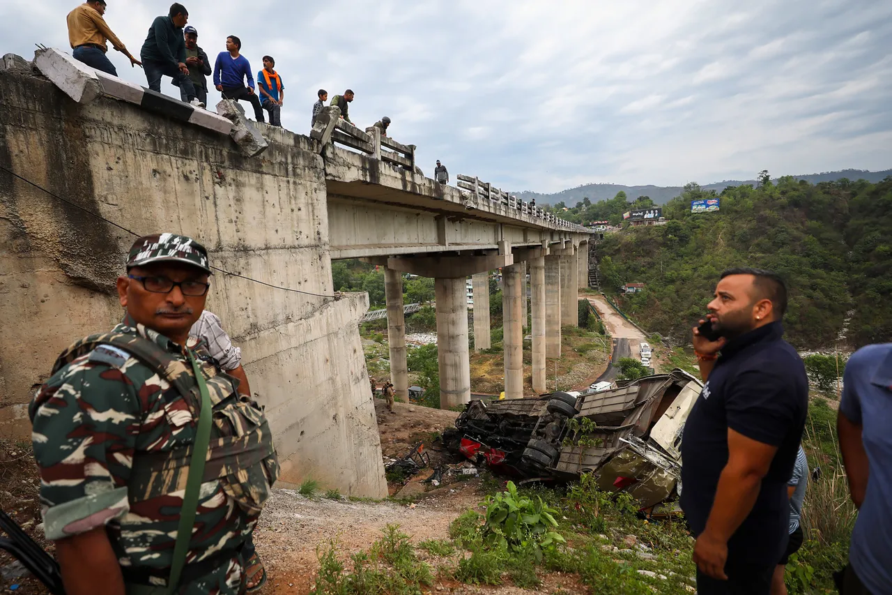 Security personnel and others near the wreckage of a bus after an accident ín which several passengers were feared dead, in Jhajjar Kotli, near Jammu