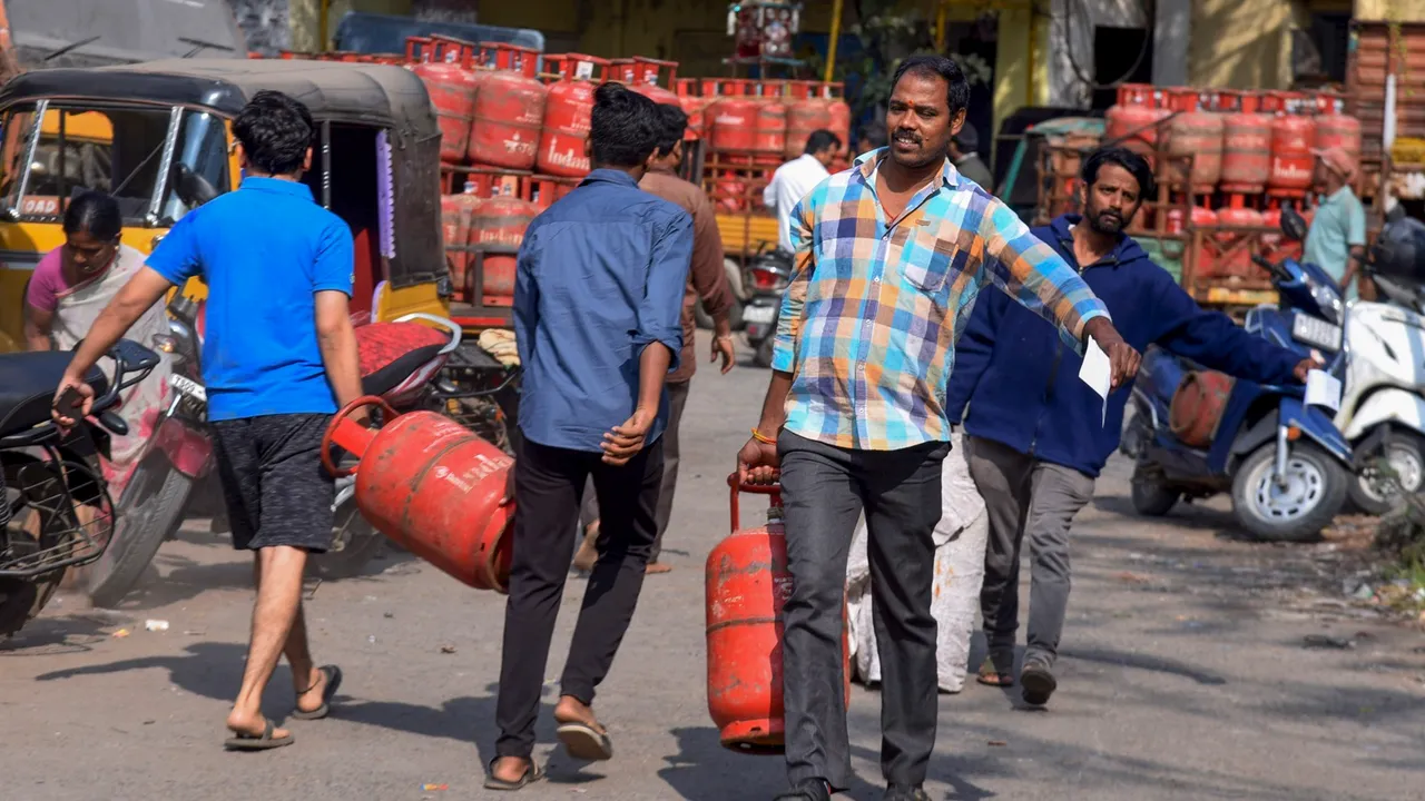 People carry LPG cylinders at a gas agency, on the day of the presentation of the Interim Budget 2024 by Union Finance Minister Nirmala Sitharaman, in Hyderabad