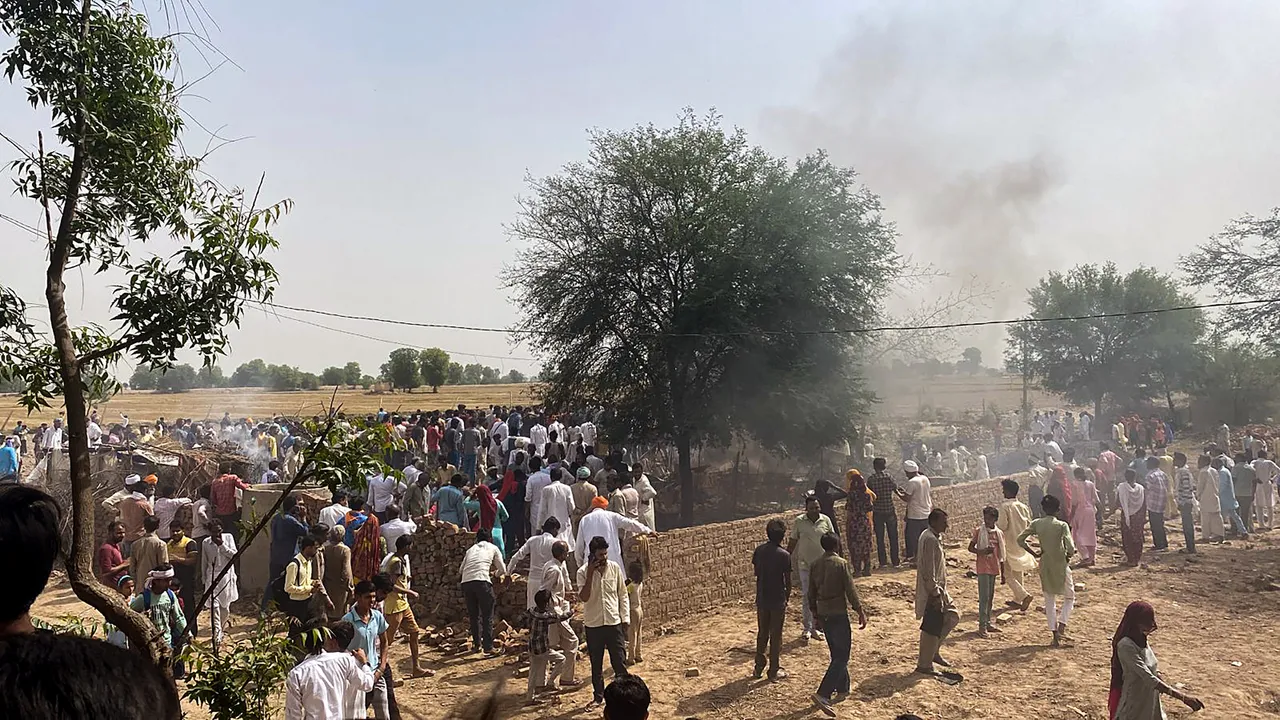 Locals gather after a MiG-21 fighter aircraft of the Indian Air Force (IAF) crashed in Hanumangarh district