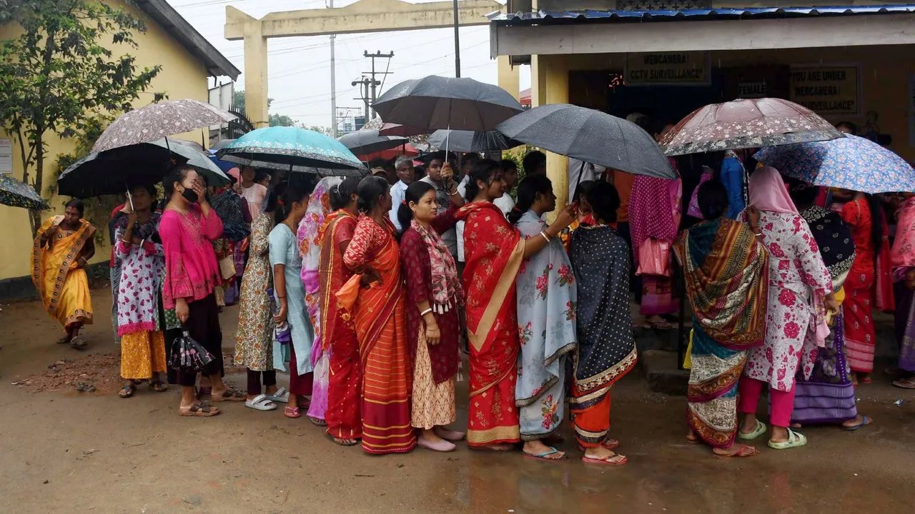 Voters wait in a queue at a polling station to cast their votes during the 3rd phase of Lok Sabha elections,in Guwahati, Tuesday, May.7, 2024